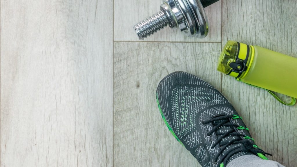 Fitness objects isolated on wooden background. Gray Sneakers, dumbbells and water bottle. Active, healthy lifestyle, sport, fitness, and objects concept. More of my photos and videos Adobe Stock:http://bit.ly/3RqlciK More of my photos and videos Shutterstock: https://www.shutterstock.com/g/ALEKSANDRBERDYUGIN My email: bermix999@gmail.com